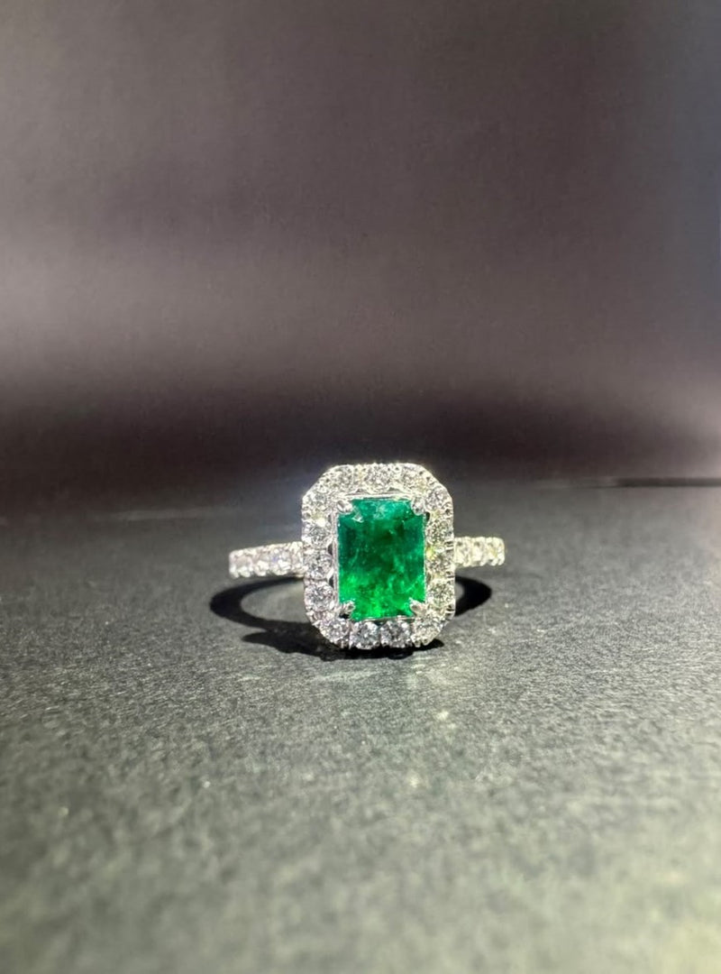 Anillo con esmeralda rectangular en halo de diamantes
